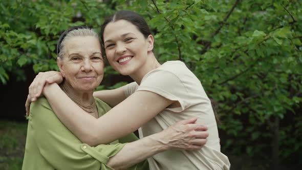 Young Woman Hugs a Senior Woman