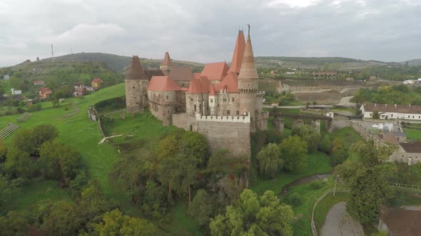 Aerial of Corvin Castle surrounded by green trees