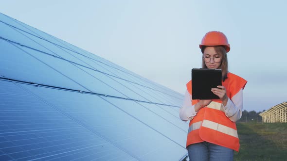 Inspector Engineer Woman Holding Digital Tablet Working in Solar Panels Power Farm