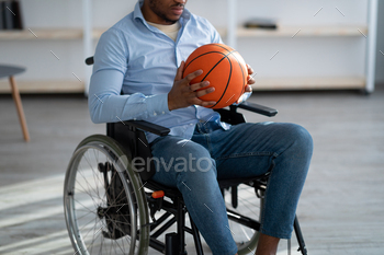 Cropped view of handicapped black man with basketball sitting in wheelchair, feeling upset over his / Photodune, Misc