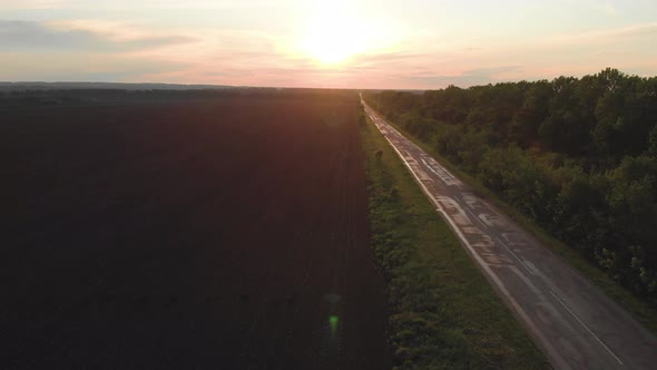 Straight Wet Lonely Road at Sunset After Rain. Perspective View of the Road.