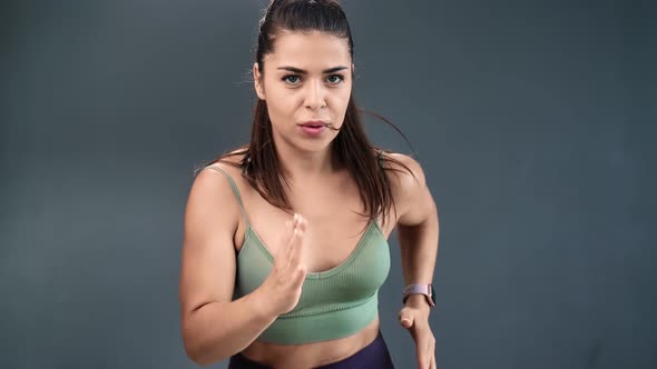 Mixed Race Athletic Woman Running Isolated on Gray Studio Background