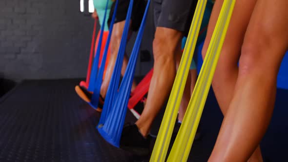 Group of people performing exercise with resistance band
