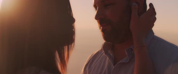 A young woman touches her boyfriend's face while they spent a romantic evening together