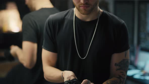 Caucasian owner of a tattoo studio taking off disposable gloves. Shot with RED helium camera in 8K.