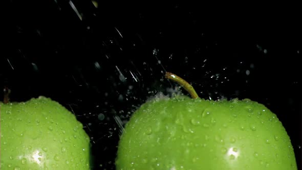 Green apples watered in super slow motion