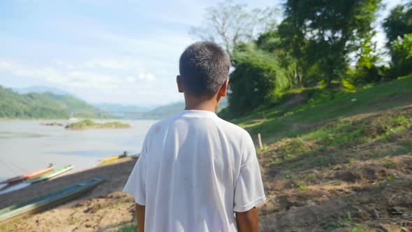 Asian Boy Walking Near The River alt