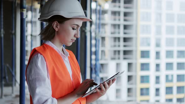 Engineer or Architect working at Construction Site. A woman with a tablet at a construction site.