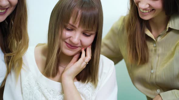 Pretty Bride and Bridesmaids Watching Wedding Catalog in Salon