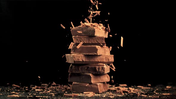 Super Slow Motion Fall of Grated Milk Chocolate on a Pyramid of Chocolate Slices