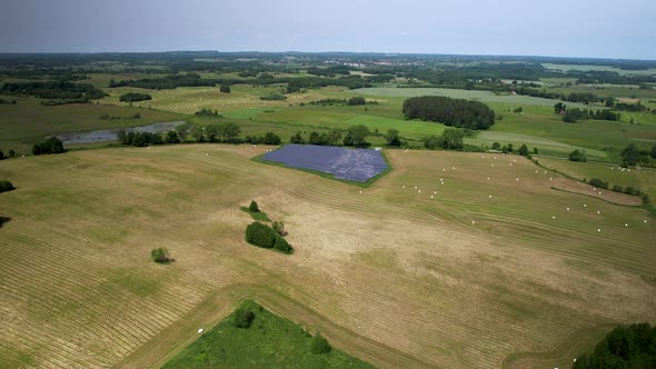 Empty Polish lands after harvesting crops with solar panel small farm - distant aerial view