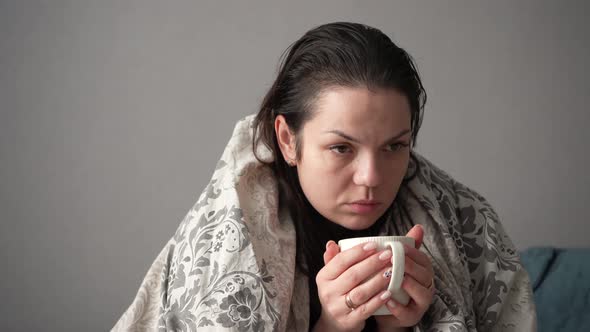 Portrait of Sick Tired Woman Patient with White Cup Sitting on Sofa