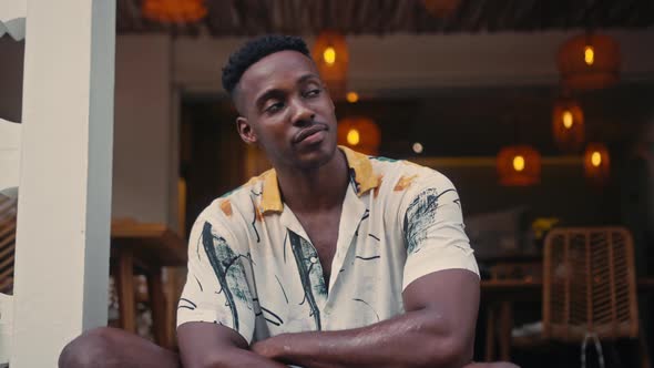 AfricanAmerican Man Smiles While Standing in a Coffee Shop