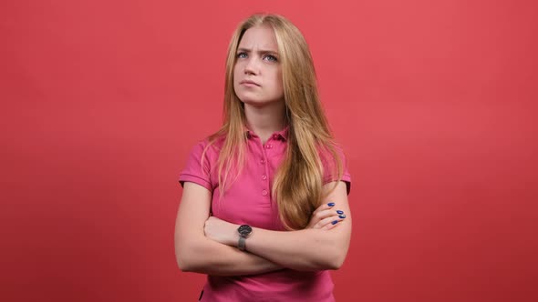 Portrait of Confused Girl Standing with Crossed Hands Thinking Intensely