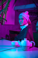 Beautiful girl with a pearl earring taking lunch in modern cafe, restaurant in neon light - PhotoDune Item for Sale