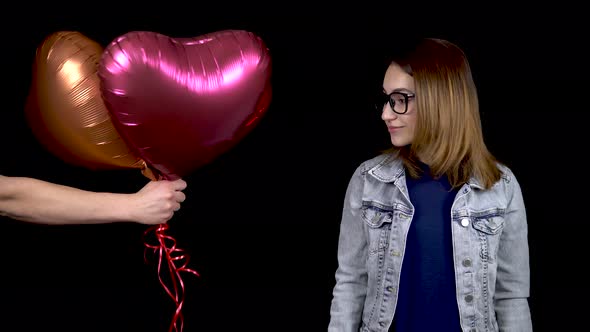 Heart Shaped Balloons Were Presented To a Young Woman. The Woman Was Surprised and Took the Balloons