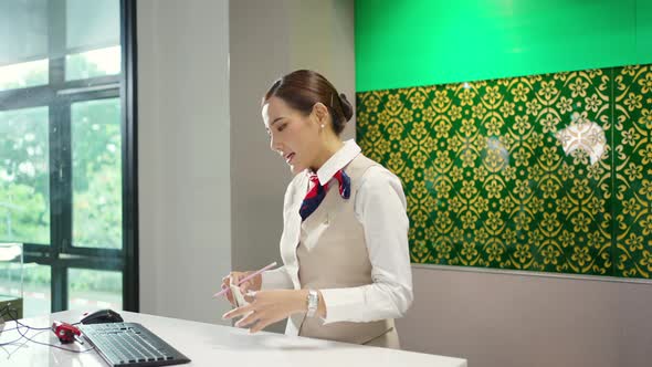 4K Asian businesswoman get boarding pass at check in counter in airport terminal.