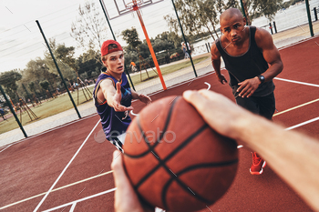 Best game ever. Close up of man holding ball while playing basketball with friends outdoors