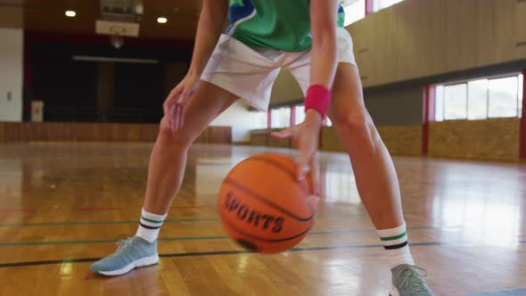 Mid section of african american female basketball player dribbling ball