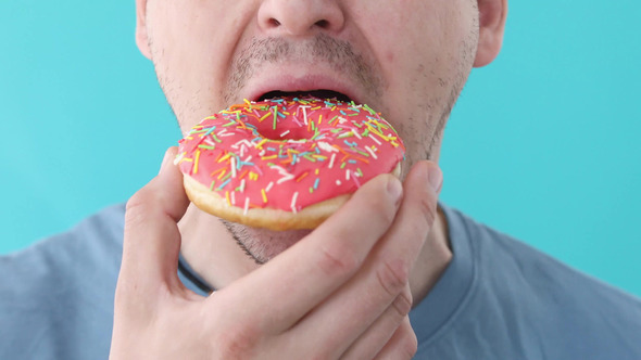 Man Eat Donut Closeup on a Blue Background