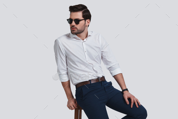 r looking away while sitting against grey background
