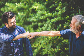 An adult hipster son and senior father talking at home, morning nature scene in the home / Photodune, Misc