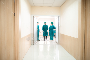 surgical team in masks and uniform keeping arms crossed and looking at camera while standing / Photodune, Misc