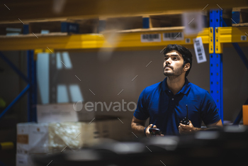 warehouse worker using bar code scanner to analyze newly arrived goods for further placement / Photodune, Misc