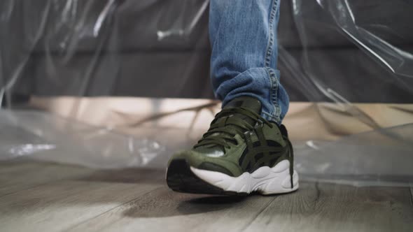 Man Stamps Foot to Music Rhythm Resting on Foiled Sofa