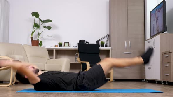 Young Fit Man Exercising at Home - He Is Doing Crunches
