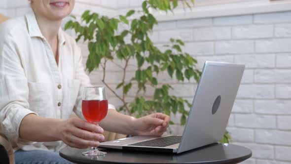 Woman with Glass of Wine By Computer