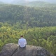 Drone Footage of a Freelancer Working on a Laptop in the Open Air Sitting on the Edge of a Rock - VideoHive Item for Sale