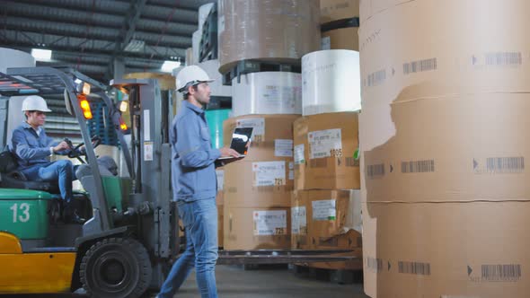 engineer staff male warehouse worker in hard hat working. walking through logistics center warehouse