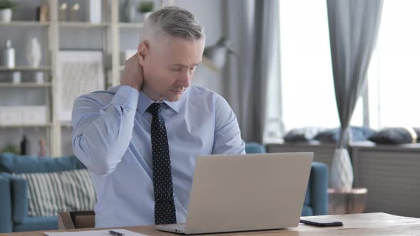 Tired Gray Hair Businessman with Neck Pain Working on Laptop