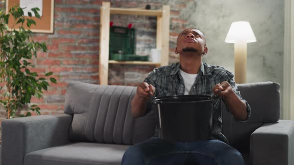 Black Man Collects Water Into Basin During Leakage in Flat