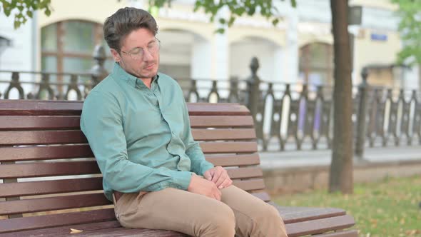 Man Falling Asleep while Sitting on Bench