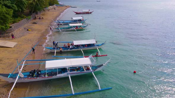 Tourist Boats Docked and Lined Up on the Sea Shore Aerial Drone Push In