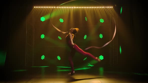 Young Sports Girl Gymnast Performs Acrobatic Exercises with Ribbon, Showing the Flexibility of His