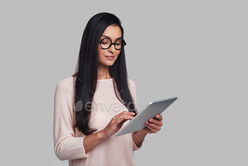 g digital tablet while standing against grey background