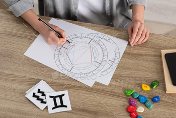 s and papers with zodiac signs on table