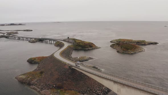 Magnificent View Of Atlantic Ocean Road in Norway With Cars Crossing The Bridge On a Cloudy Day. - A