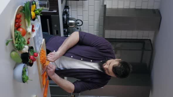 Vertical Shot of Male Chef Cutting Vegetables and Cooking in the Kitchen, Slow Motion