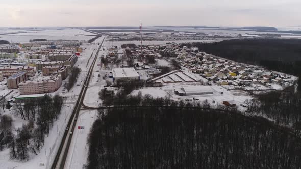 City with Buildings Covered with Snow and Forest in Winter