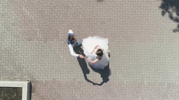 Top down aerial view of wedding couple dancing in a park 25