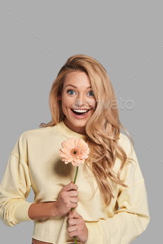 lower and looking at camera while standing against grey background