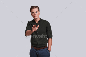 t and gesturing while standing against grey background