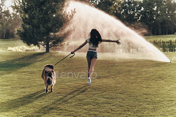 oung woman playing with her dog while running outdoors
