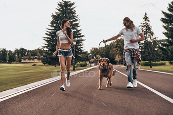 ouple running with their dog while spending time outdoors