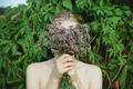 woman hold fresh cutting oregano plant bouquet and and hide face - PhotoDune Item for Sale