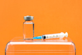 Vaccine with syringe on orange background - PhotoDune Item for Sale